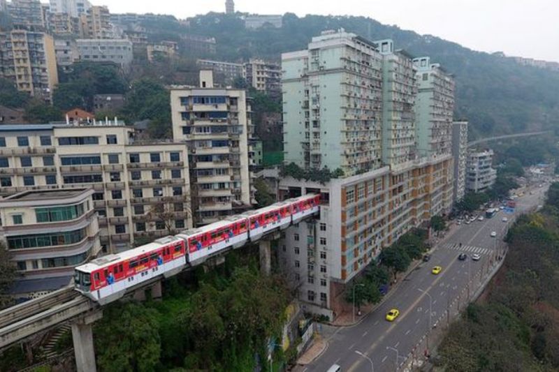 Train passing through 19-storey apartment building in China makes a strong impression on tourists