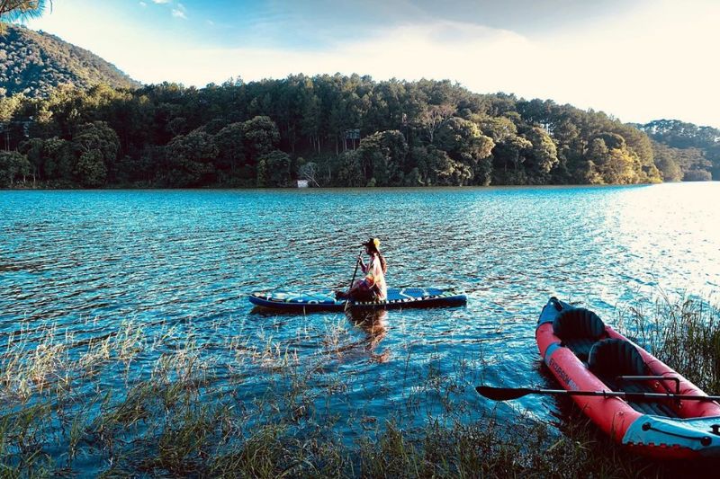 Tourists enjoy the beautiful scenery of Tuyen Lam Lake on the boat
